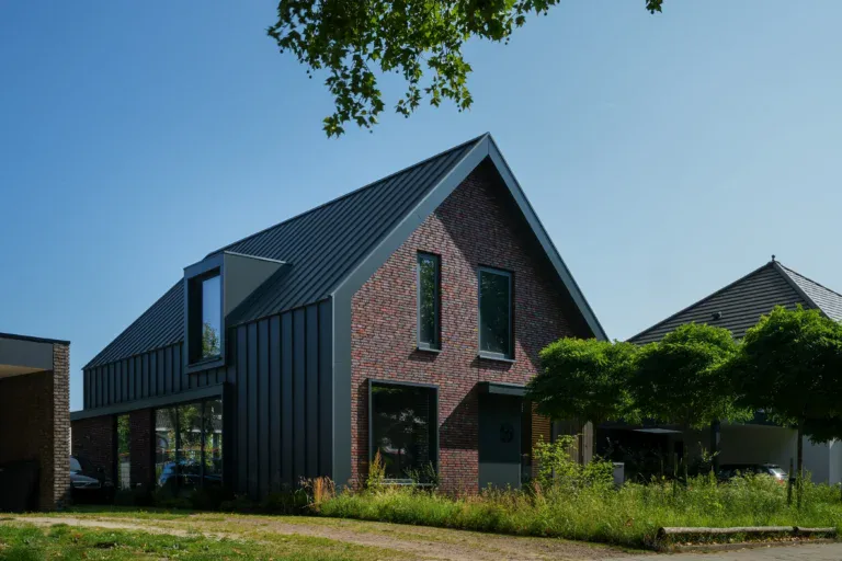 Moderne woning in Asten met strakke architectuur, gecombineerd met natuurlijke materialen en grote ramen voor veel natuurlijk licht.
