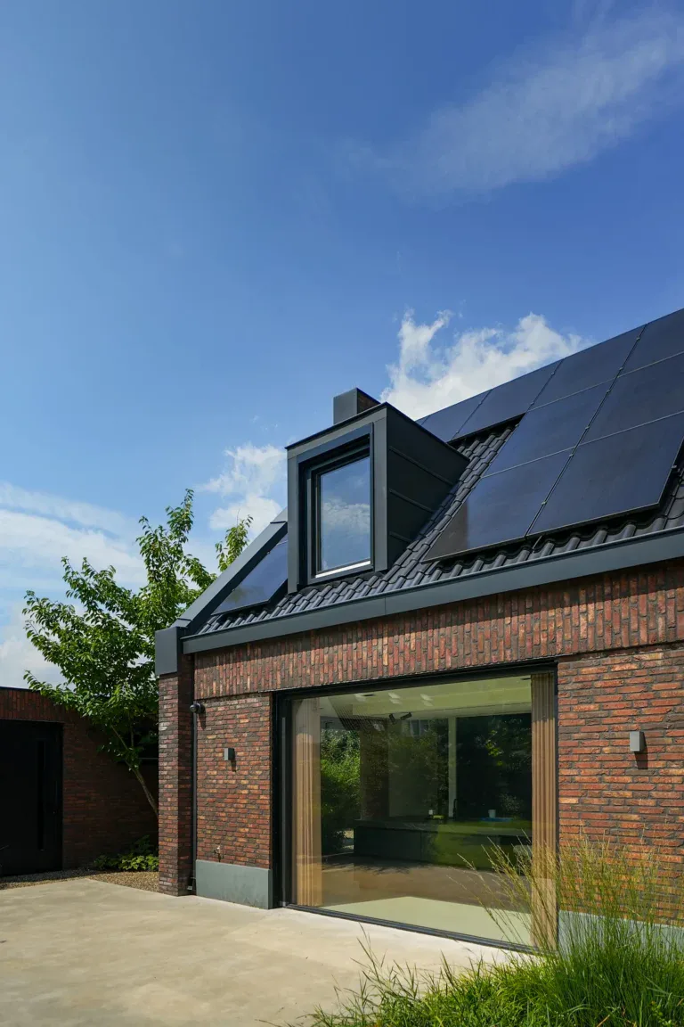 Detailopname bakstenen gevel met dakkapel en schuifpui, woning Helmond