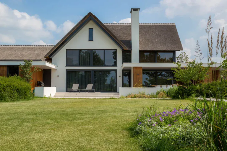 Tuingevel villa Someren met rieten kap, stucwerk en overdekte buitenruimte