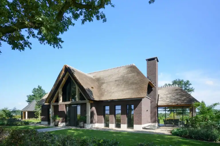 Exterieur voorgevel landhuis Venhorst met metselwerk, cement smeerplint en rieten kap