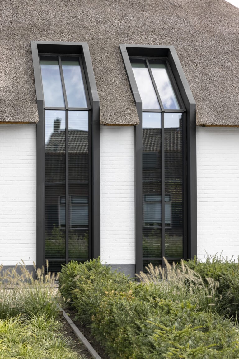 Detailopname schuine raampartijen in rieten kap villa Budel