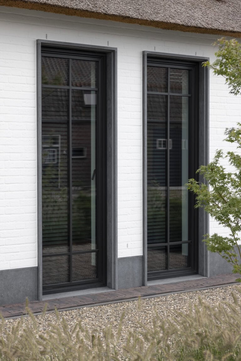 Detail opname villa Budel, aluminium kozijnen met natuursteen kader en plint
