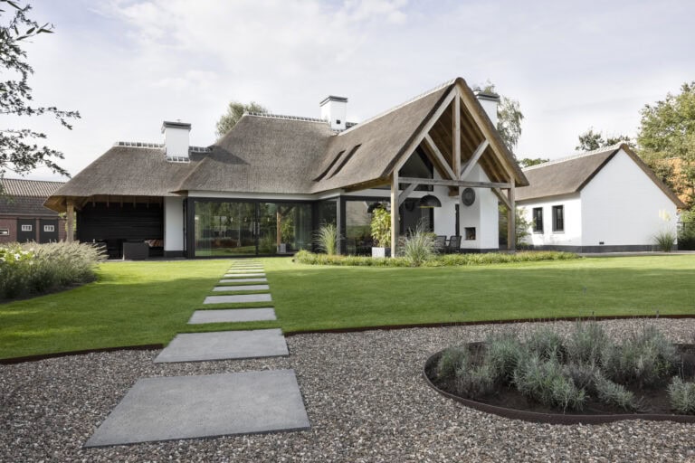 Tuingevel villa Budel met houten kapconstructie, glaspartijen en rieten kap