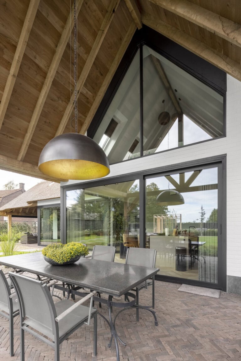 De eikenhouten overkapping als verbindingsstuk van de keuken villa Budel