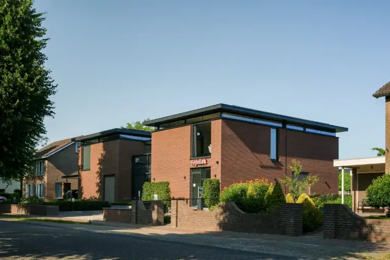 Gemengd gebouw Lierop met horizontaal gestrekt metselwerk, slanke overstekken en bandramen