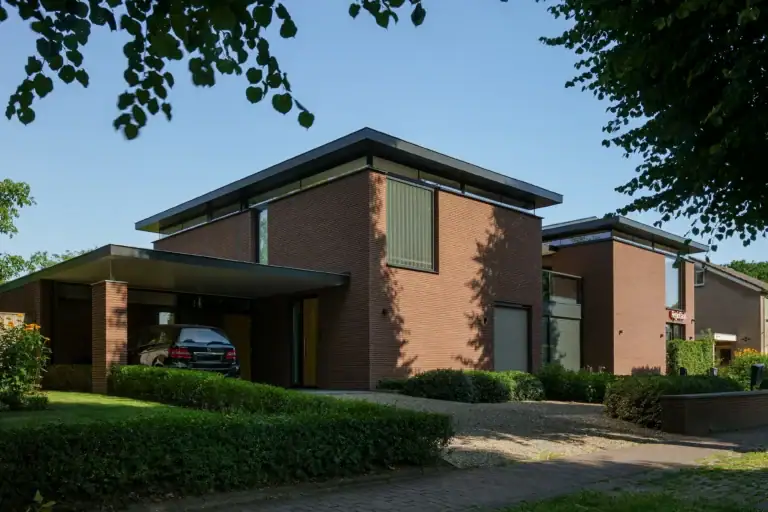 Gemengd gebouw Lierop met horizontaal gestrekt metselwerk, slanke overstekken en bandramen